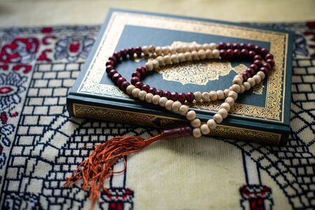 Quran - holy book of Muslims religion, Concept: open book holy prayers for god, Friday In the month of Ramadan  religion Islamic worshiping faith and learn koran and rosary put on wooden  boardsの写真素材