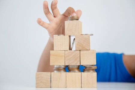 Children's hands putting money coins to a stack of coins on the tableconcept: Saving money wealth and financial Personal, finance management  loan for a home,diagram chart earnings to plan profitの写真素材
