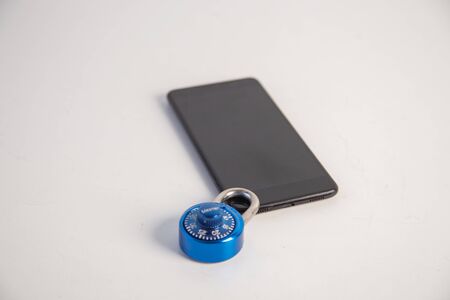 abstract  digital devices detox, Smartphone  unlock metal security lock key on wooden table,
Concept: hacker Password for data technology digital crime financeの写真素材