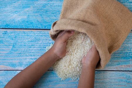 ZAKAT donation for Muslim according to religious principles during the Ramadan month, concept: rice grain in bow and rosary on woodの写真素材