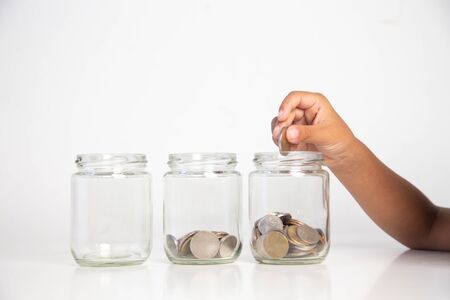 child's hand holding a coin in a glass bottle,Concept: saving  coin family money for home dreams,symbol growing  investment success wealth to  benefit,
business growth  banking for  cash
の写真素材