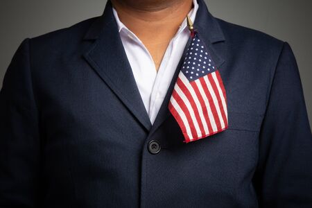Businessman in a suit holding USA flag back background,
concept:4th of July independence day, symbol celebration for success education to  patriotic, country  democracy freedom to  Americanの写真素材