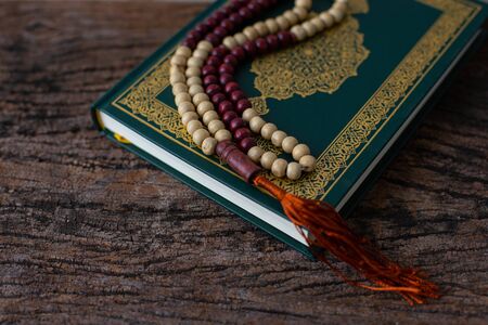 Quran - holy book of Muslims religion, Concept: open book holy prayers for god,Friday In the month of Ramadan  religion Islamic worshiping faith and learn koran and rosary put on wooden  boardsの写真素材