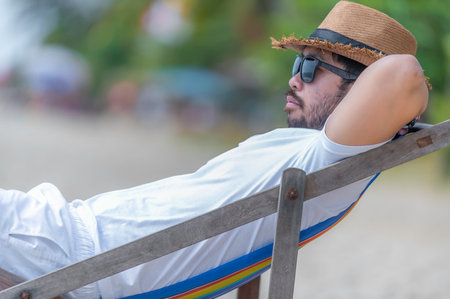 Asian man sitting chair beach inside sea,Relax time at summer