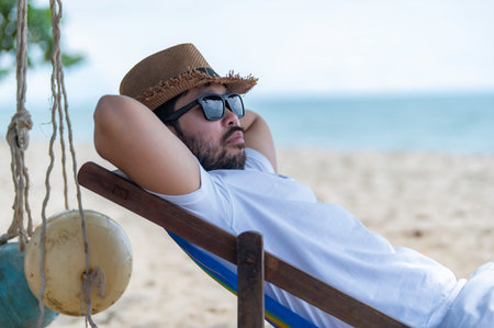 Asian man sitting chair beach inside sea,Relax time at summerの写真素材