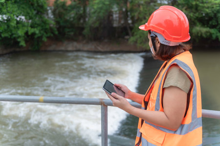 Asian Female engineering working 
 at sewage treatment plant,Marine biologist analysing water test results,World environment day concept,Check the PH value of the water before using it for treatment.の写真素材