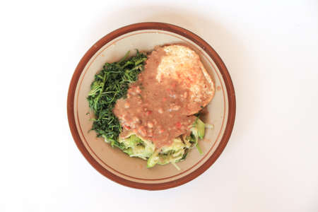 Nasi Pecel. Traditional Javanese rice dish of steamed rice with vegetable salad, peanut dressing, and fried egg.の写真素材