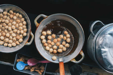 Cooking meatballs in the boiling oil in frying panの写真素材