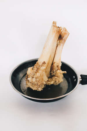 Raw stew beef bone soup in a pan isolated on white background.の写真素材