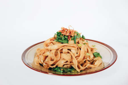 Stir fried flat noodle and pork with dark soy sauce. Indonesia said called Bakmie Jowo or Fried kwetiau isolated on white backgroundの写真素材