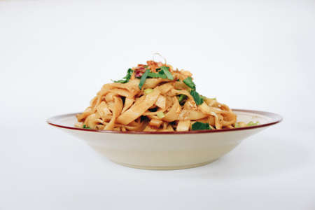 Stir fried flat noodle and pork with dark soy sauce. Indonesia said called Bakmie Jowo or Fried kwetiau isolated on white backgroundの写真素材