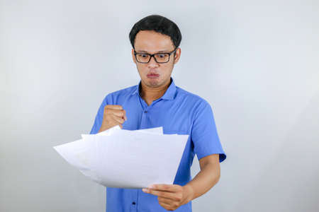 Young Asian Man wear blue shirt is happy and smiling when pointing and look into the watch isolated...