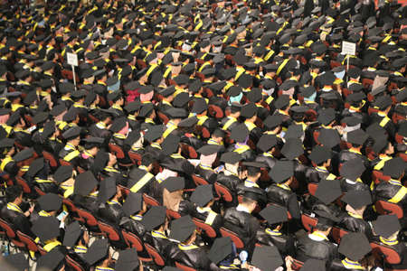Top view of group of university graduates in black gowns lines up for degree in university graduation ceremony. Yogyakarta, Indonesia - December 2019.のeditorial素材