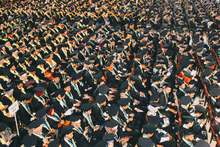 Top view of group of university graduates in black gowns lines up for degree in university graduation ceremony. Yogyakarta, Indonesia - December 2019.のeditorial素材