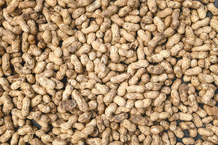 Peanuts in shell texture background. Raw peanuts on display at a farmer's market. Close up image.