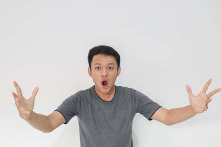 Wow and shocked face of Young Asian man with open hand gesture. Advertising model concept.