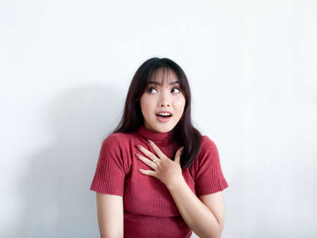 Wow and shocked face of beautiful Young Asian girl with hand touching chest wear red shirt....