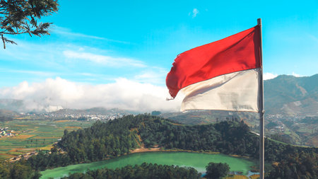 Indonesian Flag on Telaga Warna lake and mountain in Dieng Indonesia.の写真素材