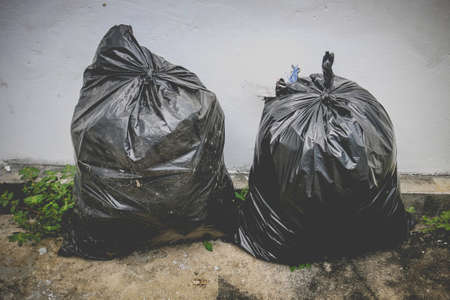 Pile of black garbage on the corner of wall, pollution trash.