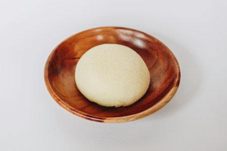 Bakpia Kukus Cake or Steamed Bakpia Cake with Cheese Flavour on wooden plate isolated on white...