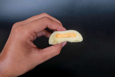 Bakpia Kukus Cake or Steamed Bakpia Cake with Cheese Flavour on hand isolated on white background. Indonesia-china traditional cake from yogyakartaの写真素材