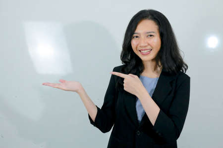 Business young asian girl is Happy and smile face with hand point on empty space.の写真素材