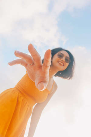 Portrait of happy smiling Asian woman with blue sky view from the bottom.の写真素材