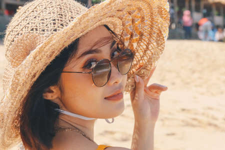Portrait of happy smiling asian woman on the beach on a beautiful . Pretty girl asian in casual looking away and smile , laughing. The beach beautiful at bright skyの写真素材