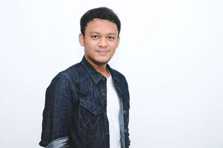 Portrait of smiling young asian man wearing white shirt and denim pant isolated on white.