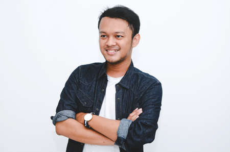Portrait of smiling young asian man wearing white shirt and denim pant isolated on white.の写真素材