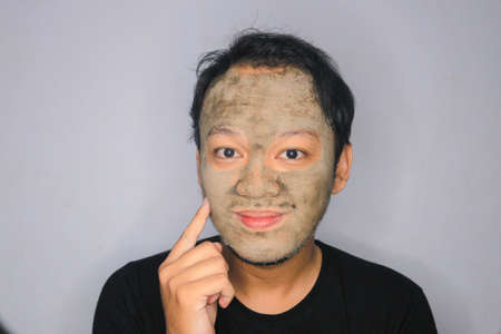 Smile Asian Man was happy at the camera when he use beauty face maskの写真素材