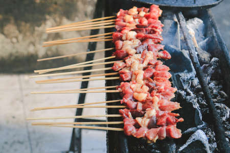 Sate Kambing or goat satay on red fire grilling by people.の写真素材