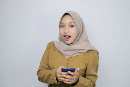Shock government worker women when using a smartphone. PNS wearing khaki uniform.