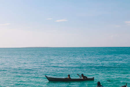 Children paddle in boats near stilted houses in The Celebes Sea. Rote, Indonesia - APRIL, 2020.の写真素材