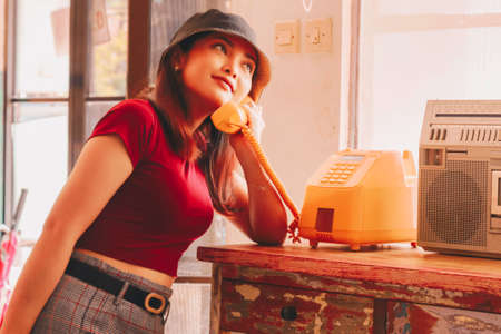 A portrait of a young Asian woman using vintage telephoneの写真素材