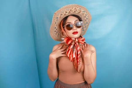 Traveling concept of a young Asian retro woman isolated by a blue background