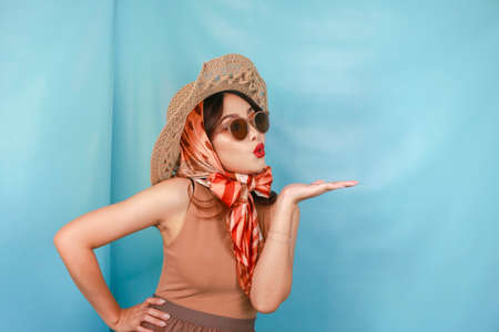 Young Asian shocked woman isolated by a blue background pointing copy space on the side.の写真素材