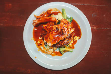 A plate of chicken and beef steak and sausages