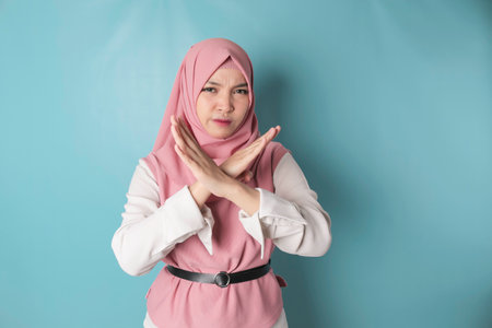 Beautiful Asian Muslim woman with hand gesture pose rejection or prohibition with copy spaceの写真素材