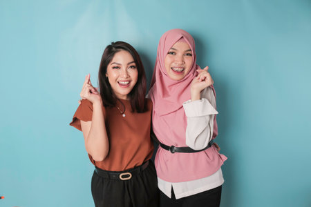 Two attractive young Asian women feels happy and a romantic shapes heart gesture expresses tender feelings and friendship conceptの写真素材
