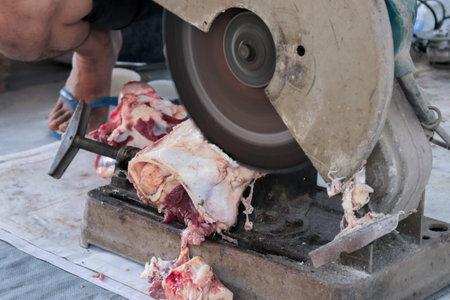 A portrait of Muslims cutting meat on Eid Al Adha by using cutting machineの写真素材