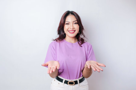 Young Asian woman presenting an idea while looking smiling on isolated white backgroundの写真素材