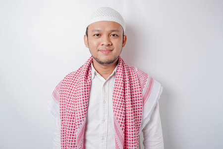 A portrait of a happy Asian Muslim man smiling isolated by white background