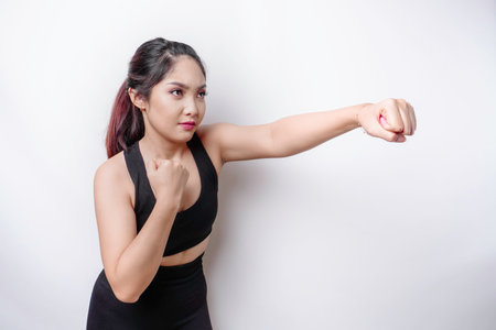 Beautiful sporty Asian woman fighter trains boxing in studio on white background. Martial arts conceptの写真素材
