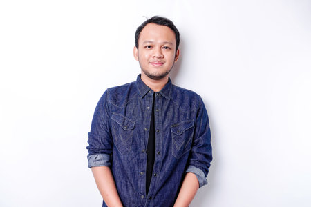 A portrait of a smiling Asian man dressed in a blue shirt, isolated by white background