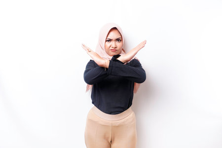 Beautiful Asian Muslim woman wearing a hijab with hand gesture pose rejection or prohibition with copy spaceの写真素材
