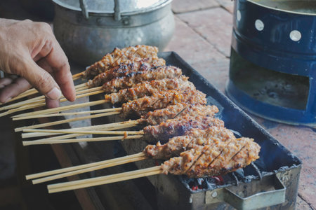 Sate Buntel or Satay Buntel is satay made from minced mutton wrapped in mutton fat is being grilled on charcoalの写真素材