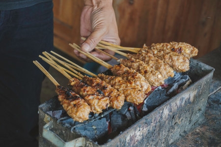 Sate Buntel or Satay Buntel is satay made from minced mutton wrapped in mutton fat is being grilled on charcoalの写真素材
