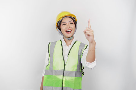 Young woman labors speaker wearing safety helmet and vest gesturing oration with hands isolated on white background. Labor's day concept.の写真素材