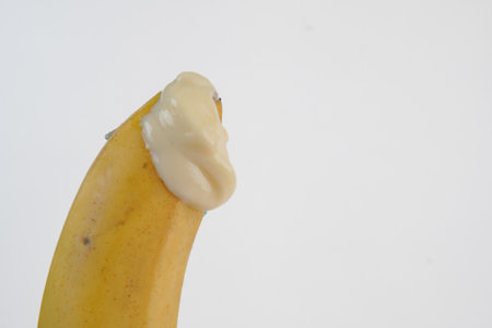 Close up of a banana with creamy texture on the tip over isolated white background.の写真素材